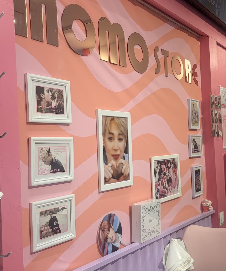 Inside Momo Store Madrid with the logo and a wall decorated with K-pop group photos